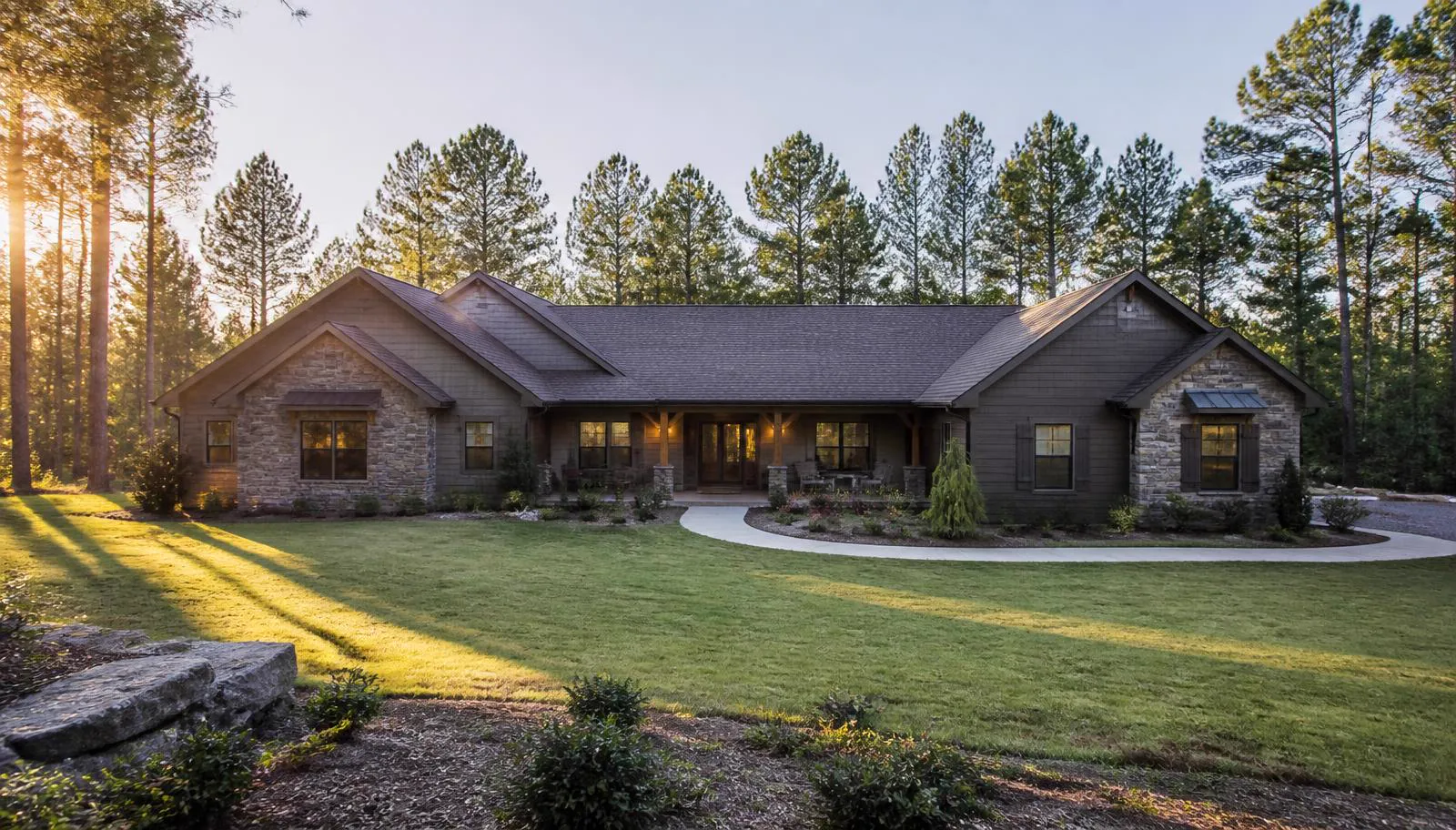 Stone-accented ranch home with covered porch framed by tall pines in Whispering Pines